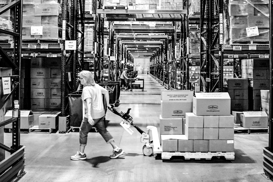 A large warehouse with workers hauling pallets